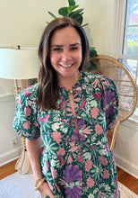 Load image into Gallery viewer, Green and purple floral printed mini dress. Puff sleeves, triple front closure, babydoll style with pockets. Light weight cotton and lined. Personally did not need tank under ties, but could be worn.
True to size, wearing size small.
Good for bump, post bump or no bump.
Step into whimsical elegance with this green and purple floral printed mini dress, perfect for breezy days and effortless style. Designed in a flattering babydoll silhouette, this dress features puff sleeves for a romantic touch and