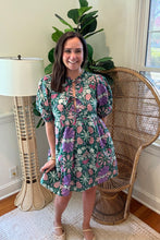 Load image into Gallery viewer, Green and purple floral printed mini dress. Puff sleeves, triple front closure, babydoll style with pockets. Light weight cotton and lined. Personally did not need tank under ties, but could be worn.
True to size, wearing size small.
Good for bump, post bump or no bump.
Step into whimsical elegance with this green and purple floral printed mini dress, perfect for breezy days and effortless style. Designed in a flattering babydoll silhouette, this dress features puff sleeves for a romantic touch and
