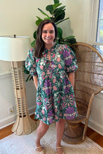 Load image into Gallery viewer, Green and purple floral printed mini dress. Puff sleeves, triple front closure, babydoll style with pockets. Light weight cotton and lined. Personally did not need tank under ties, but could be worn.
True to size, wearing size small.
Good for bump, post bump or no bump.
Step into whimsical elegance with this green and purple floral printed mini dress, perfect for breezy days and effortless style. Designed in a flattering babydoll silhouette, this dress features puff sleeves for a romantic touch and