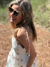 Load image into Gallery viewer, Cerise shell printed Senia midi dress. Empire waistline with gathered skirt with pockets. Contrasting solid printed hemline. Adjustable tie straps and smocking on backside for adjustable fit. Light weight cotton-linen blend and lined.
Sized up for a looser fit, wearing size small.
Good for bump, post bump or no bump!