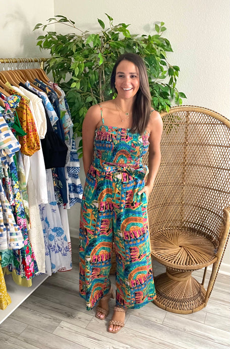 Sefina jumpsuit in paradiso print. Light weight cotton with straight pants and smocked bodice. Adjustable straps and removable tie at waist - could add a straw belt. Hits at ankle length for flats as well.  True to size. Wearing size small, but would take x-small for a more fitted look.