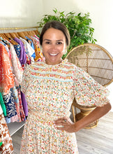Load image into Gallery viewer, Dallas mini dress with ruffle detailing on neck, arms and waistline. Slight smocking and pink tuck detailing at neck. Double lined light weight cotton with pockets. Double back tie with cotton rope and tassels.  Wearing size small, sized up from x-small for bust.