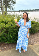 Load image into Gallery viewer, Light blue and white floral printed maxi dress. Puff sleeves, plunge neckline and tiered maxi skirt. Ruched elastic empire double banded waistline. Back zipper closure to neckline, full coverage backside. Cotton poplin.  True to size, wearing size small.   
