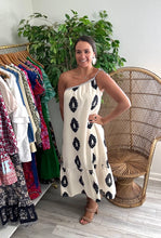 Load image into Gallery viewer, Black and ivory printed midi dress. Rope detailing one shoulder tie with wooden beads. Drop flounce hemline. Linen cotton blend and lined.  True to size, wearing size small.  Size up for bump.
