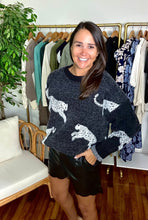 Load image into Gallery viewer, Black sweater with cheetahs. Slight high low hemline. Cotton knit blend.  Fits roomy, true to size, wearing size small.
