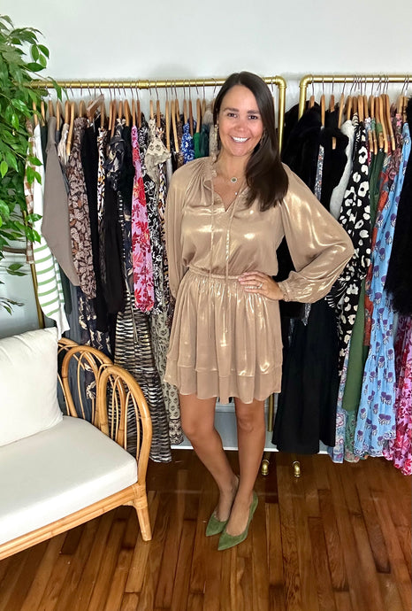 Gold metallic mini dress. Tiered layered mini skirt with empire waist, ruffle detailing at neckline and option front tie closure. Elastic waist and functional buttons at cuffs. Silk poly blend.  True to size, wearing size x-small.