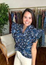 Load image into Gallery viewer, Dynamite floral printed indigo blouse. Double ruffle flutter sleeves, ruffle mock collar neckline with front function buttons with parallel ruffle detailing. Cotton. Covers most of front and backside, tailored to tuck well.  True to size, wearing size x-small.   
