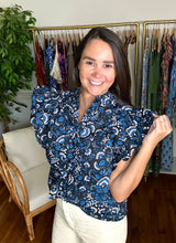 Load image into Gallery viewer, Dynamite floral printed indigo blouse. Double ruffle flutter sleeves, ruffle mock collar neckline with front function buttons with parallel ruffle detailing. Cotton. Covers most of front and backside, tailored to tuck well.  True to size, wearing size x-small.   
