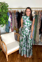 Load image into Gallery viewer, Green and silver tulip and palm printed jumpsuit. Mock collar, shoulder pads and empire waist. Flare pants and structured bodice. Back zipper closure. Poly silk blend.  True to size, wearing size small.

