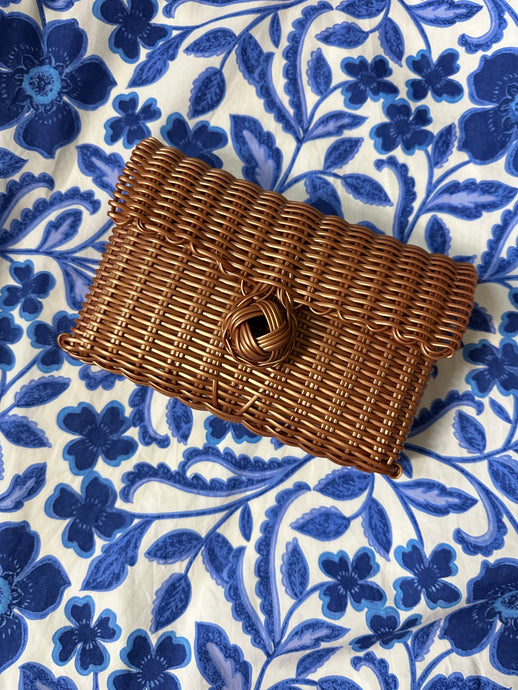 Copper woven clutch with front knot closure. Woven plastic, perfect for spring and summer.