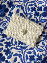 Load image into Gallery viewer, White woven clutch with front knot closure. Woven plastic, perfect for spring and summer.
