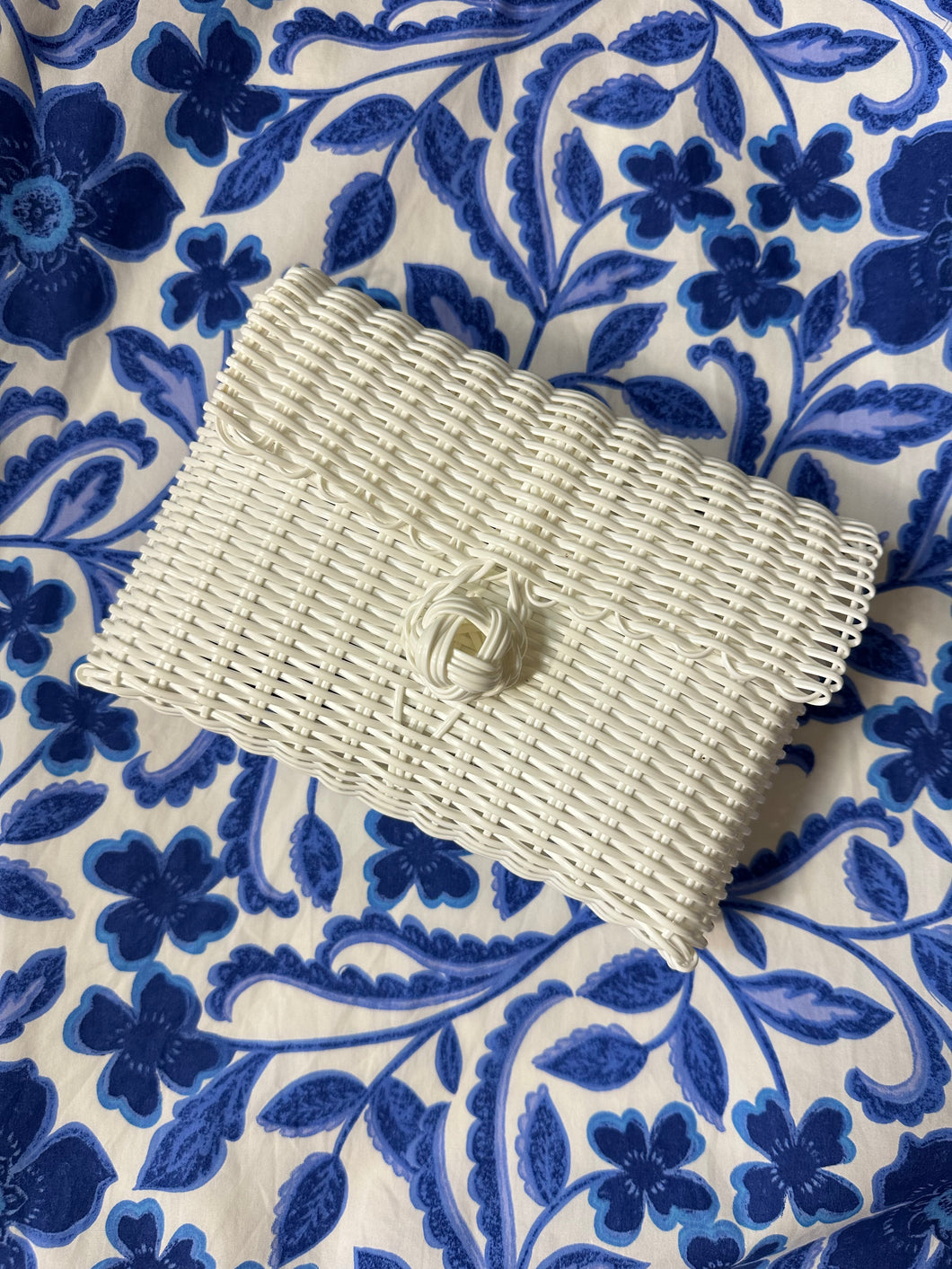 White woven clutch with front knot closure. Woven plastic, perfect for spring and summer.