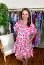 Load image into Gallery viewer, Leaf printed pink and blue mini dress with ruffle sleeves and drop waistline flounce skirt with pockets. Front tie closure and ruffle detailing at neckline. Woven cotton and lined.  True to size, wearing size small.  Good for bump, post bump or no bump!
