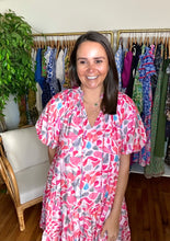 Load image into Gallery viewer, Leaf printed pink and blue mini dress with ruffle sleeves and drop waistline flounce skirt with pockets. Front tie closure and ruffle detailing at neckline. Woven cotton and lined.  True to size, wearing size small.  Good for bump, post bump or no bump!
