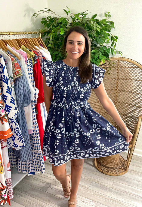 Indigo mini dress with white and blue hand block print pattern. Smocked bodice, ruffle flutter sleeves, ruffle at empire and gathered skirt. Back keyhole closure. Light weight cotton.   True to size, wearing size x-small.