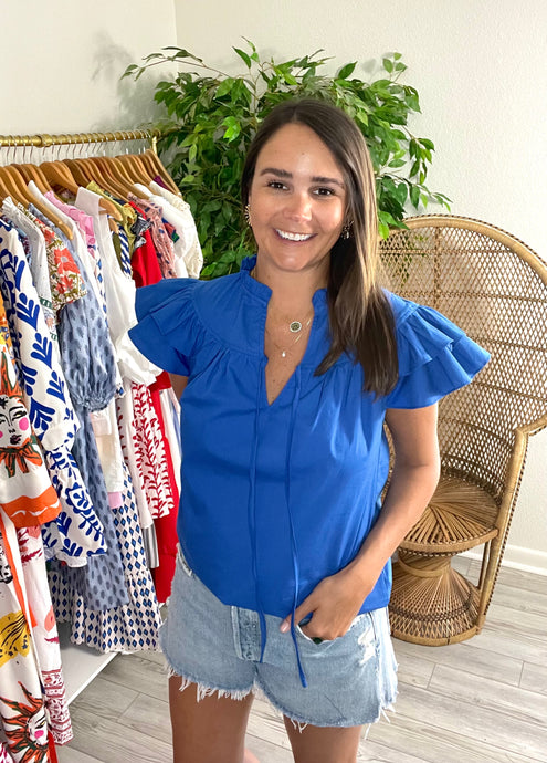 Cobalt blue Anya blouse with double ruffle sleeves. Front tie closure and straight bodice. Cotton poplin.  If between sizes or want a less fitted look, size up, wearing size x-small.