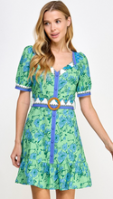 Load image into Gallery viewer, &lt;p&gt;Blue and green printed mini dress with contrasting block printed belt with rattan buckle. Squared neckline, puff sleeves and ruffle hemline. Poly silk blend.&lt;/p&gt; &lt;p&gt;Runs a little small, wearing size medium. If between sizes, size up.&lt;/p&gt; &lt;p&gt;I carry my weight in my stomach, wanted to have a little extra room.&lt;/p&gt;
