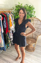 Load image into Gallery viewer, Black romper with dramatic ruffle sleeves, front and black. Front functional wooden buttons, pockets and back tie closure. Light weight cotton linen blend.  Fits roomy, wearing size small with room.
