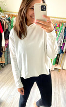 Load image into Gallery viewer, White cropped hoodie with raw hemline and a slight high low hem. Cotton with terrycloth blend inside lining. Banded cuff.  True to size, wearing size small. 

